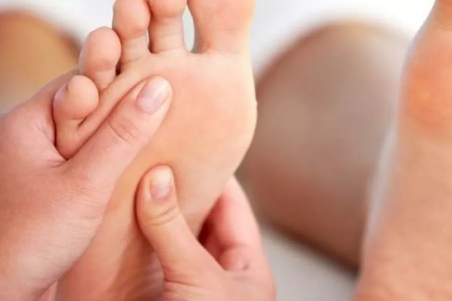 Terapeuta haciendo una reflexología en los pies