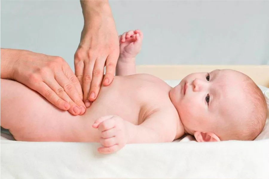 Terapeuta examinando el abdomen de un bebé