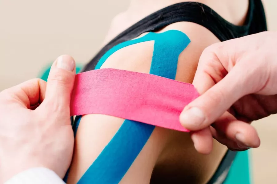 Doctor colocando bandas de kinesiotaping