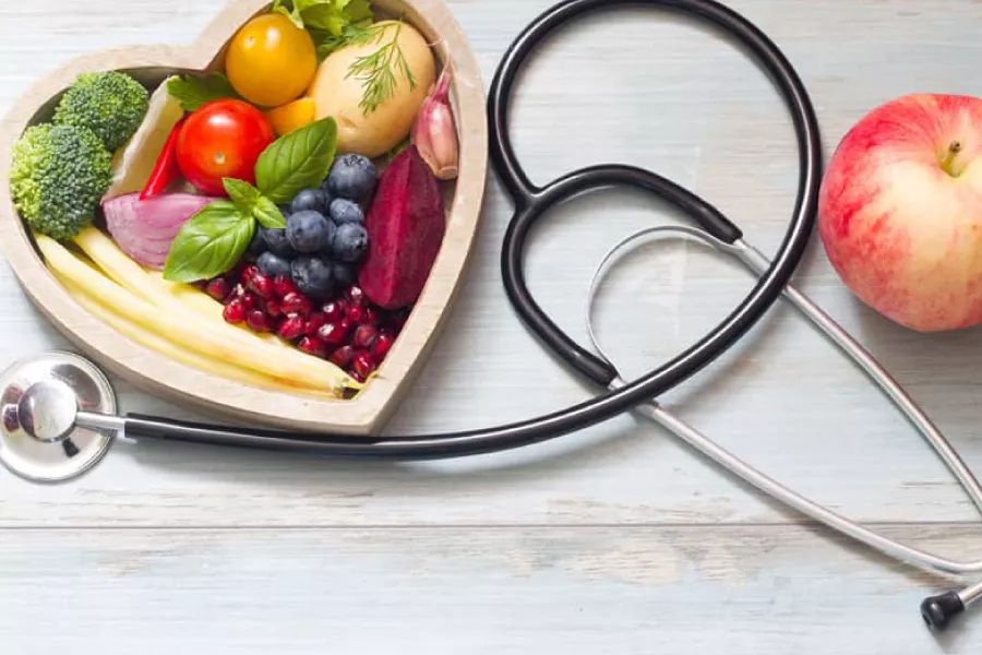 Plato de corazón con frutas y verduras y un estetoscopio