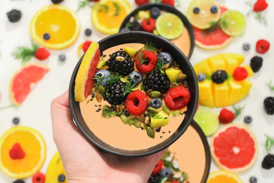 Mano sosteniendo un plato de frutas y semillas