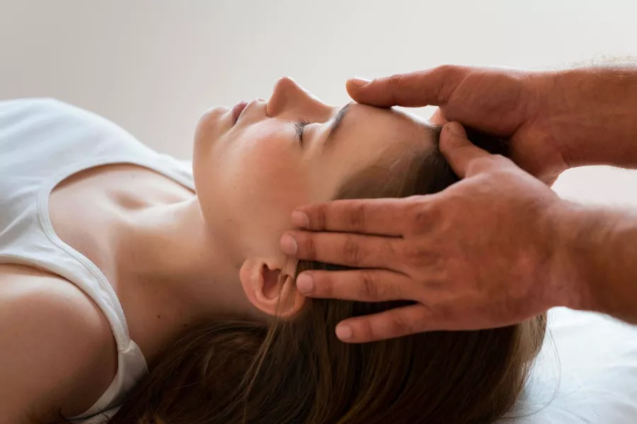 Doctor haciendo una osteopatía craneal a una mujer
