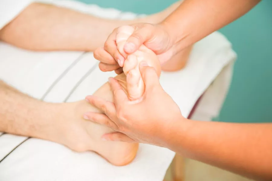 Doctora haciendo un masaje en los pies a un hombre